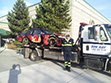 Ron May Towing flatbed tow truck transporting a racecar to the track